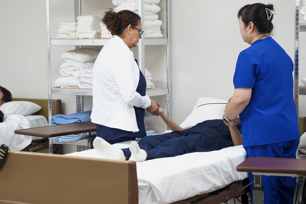 Nurse instructor coaching a CNA student at the bedside during Texas nurse aide exam prep at DMS Care Training Center